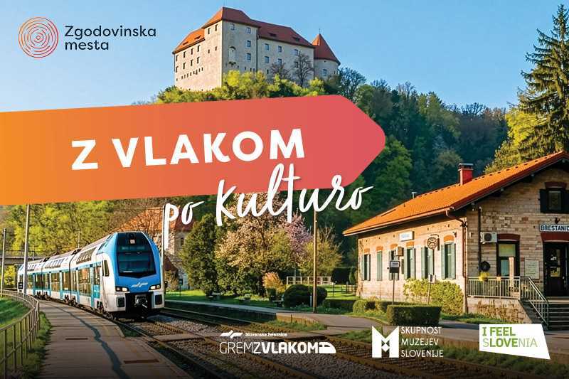 Z vlakom po kulturo Potniški vlak pripelje na železniško postajo pod gradom na hribu. Čez fotografijo je napis »Z vlakom po kulturo«, ob robu pa so logotipi Zgodovinskih mest Slovenije, Slovenskih železnic, Skupnosti muzejev Slovenije in I feel Slovenia.